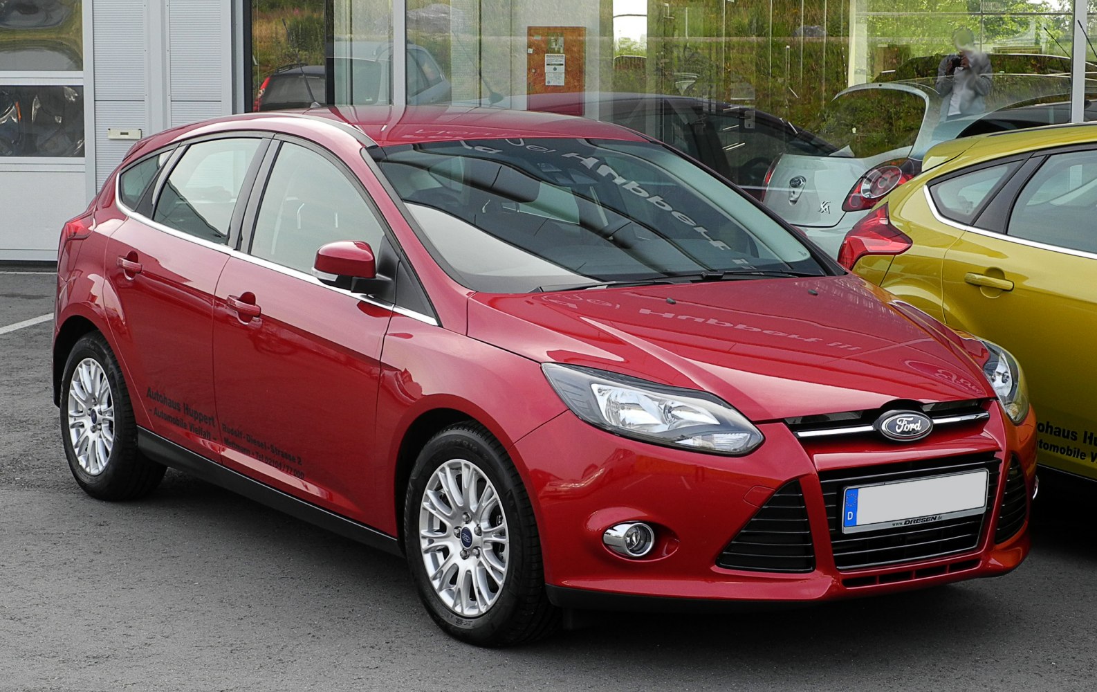 Red hatchback with sharp headlights and chrome wheels