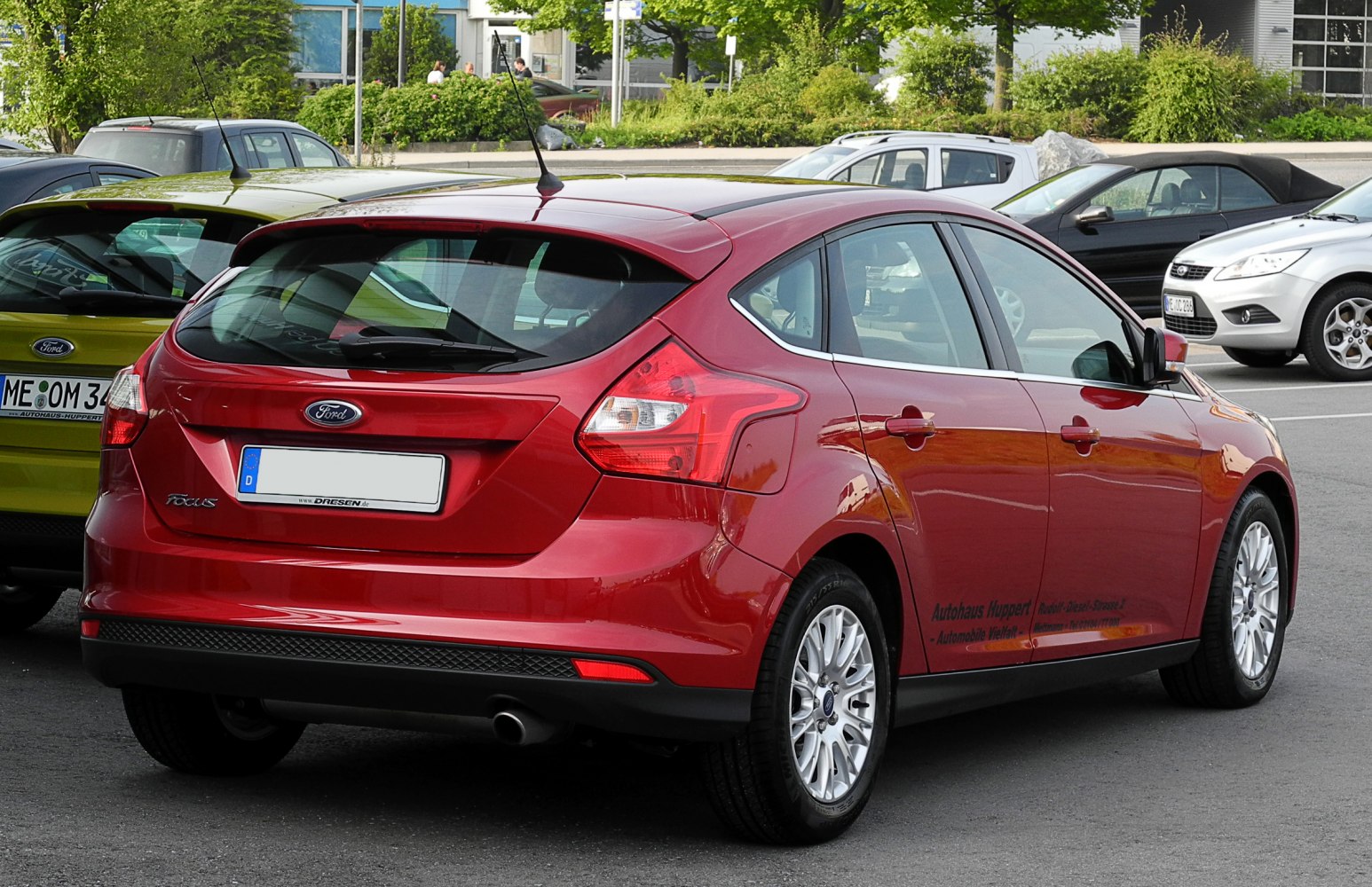 Rear and side view of a red hatchback with distinctive taillights and alloy wheels.