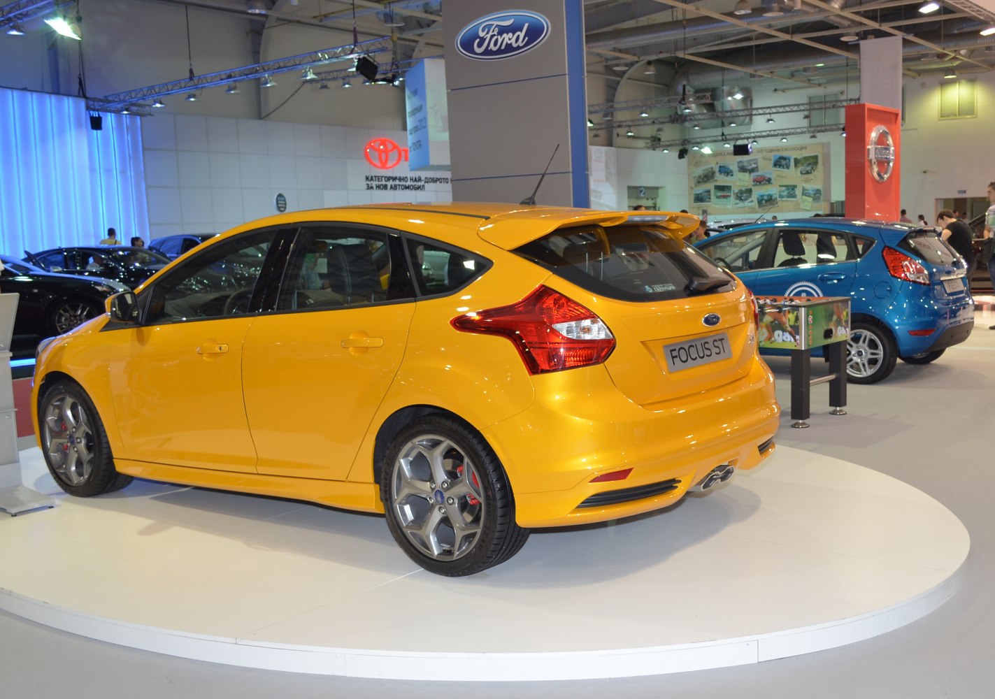 Yellow sporty hatchback with rear spoiler and dual exhaust
