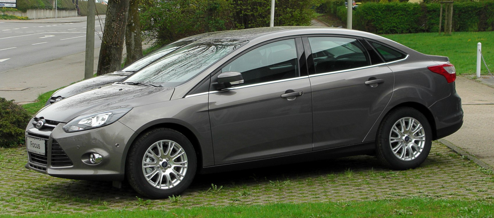 Side profile of a gray sedan with alloy wheels