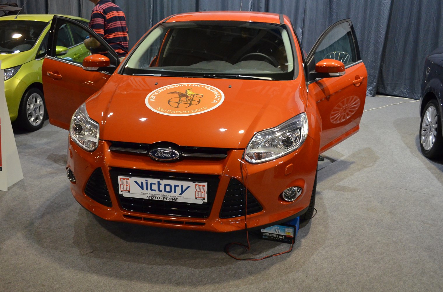 Front view of orange car with open front doors.
