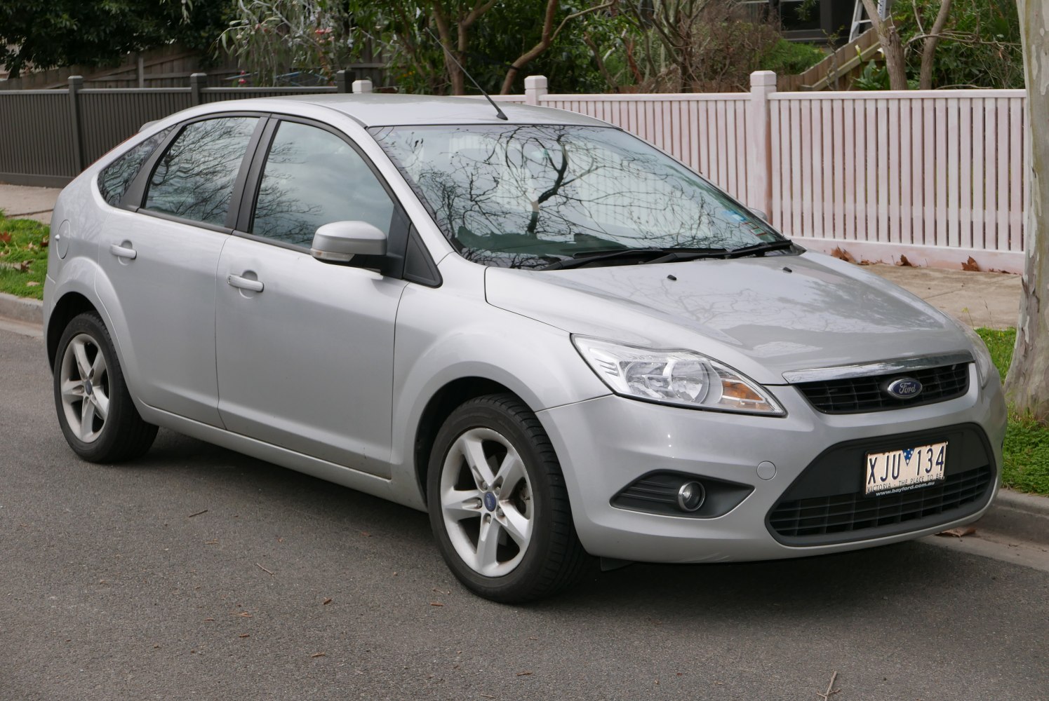 Silver hatchback with alloy wheels and sleek headlights front side view