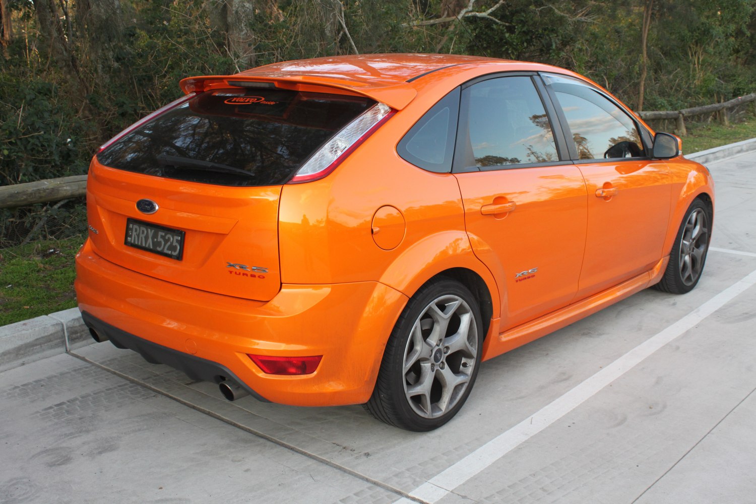 Bright orange hatchback with rear spoiler and alloy wheels