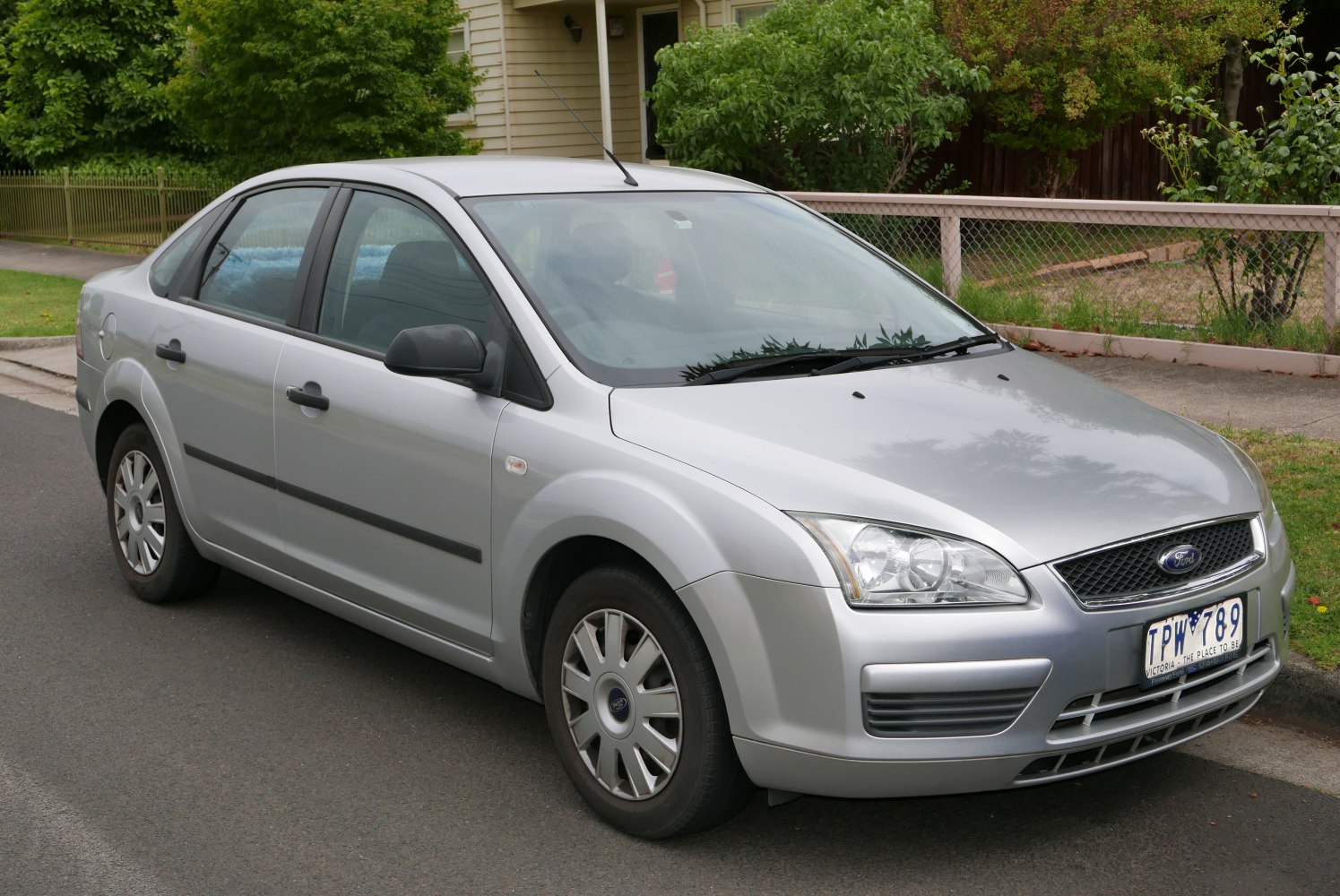Silver four-door sedan with distinct headlights and wheel covers