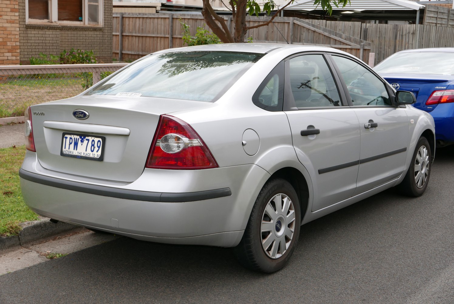 Silver sedan rear view with signature tail lights and hubcap wheels
