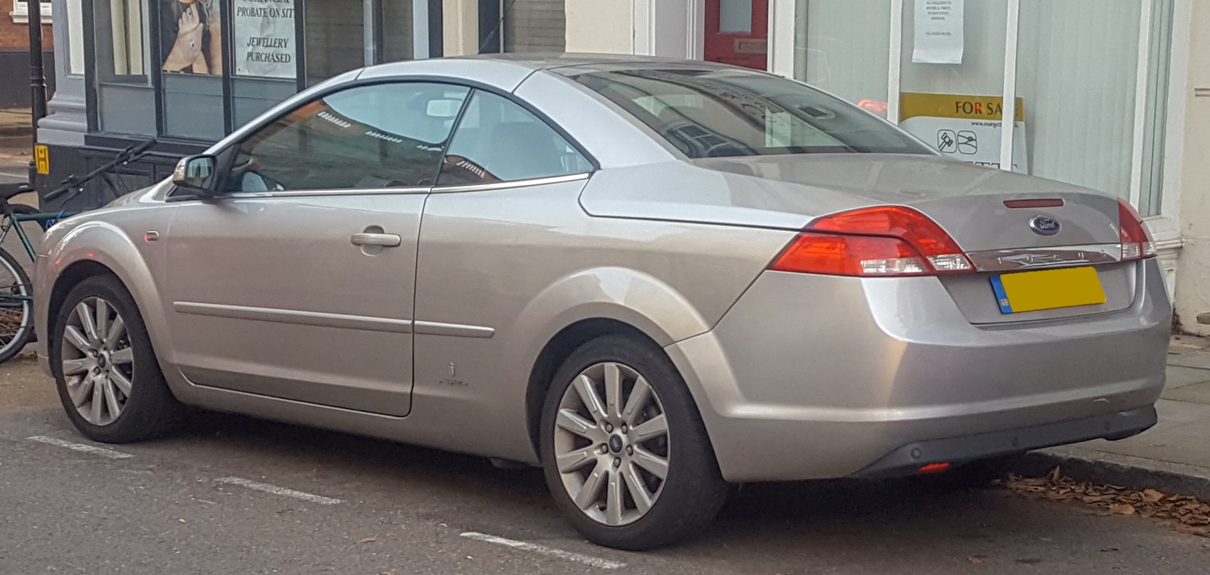 Silver hardtop coupe with rear roof design and alloy wheels