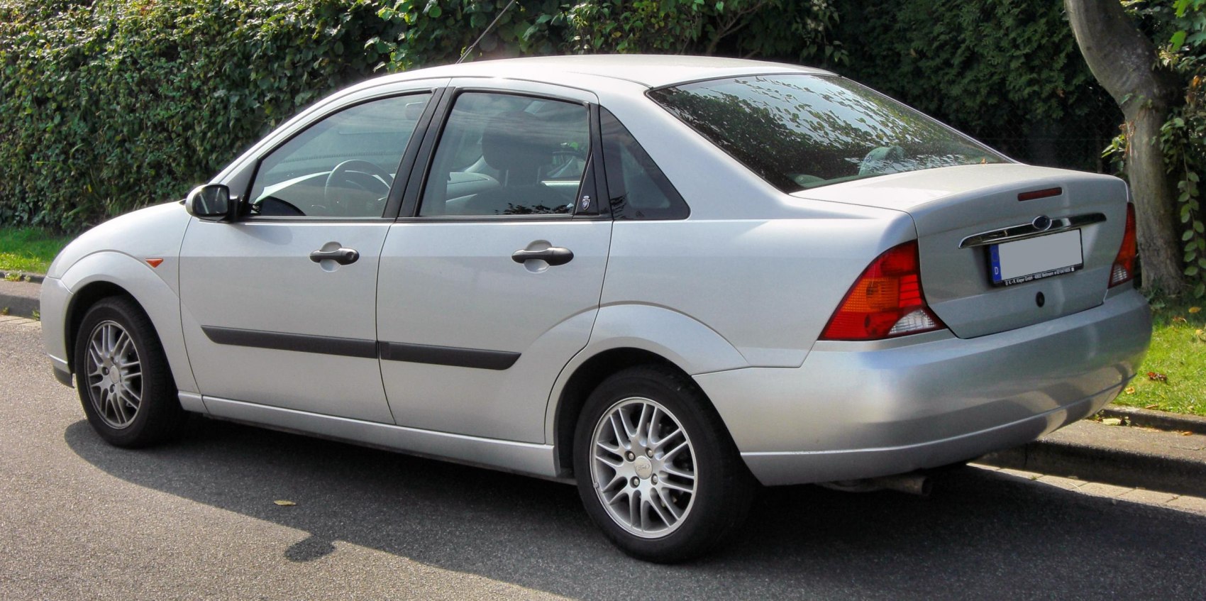 Silver compact sedan rear side view with alloy wheels