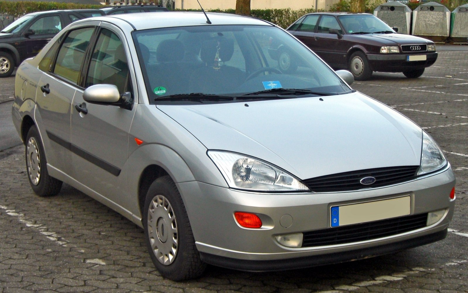 Silver mid-size sedan front and side view with clear headlights and steel wheels
