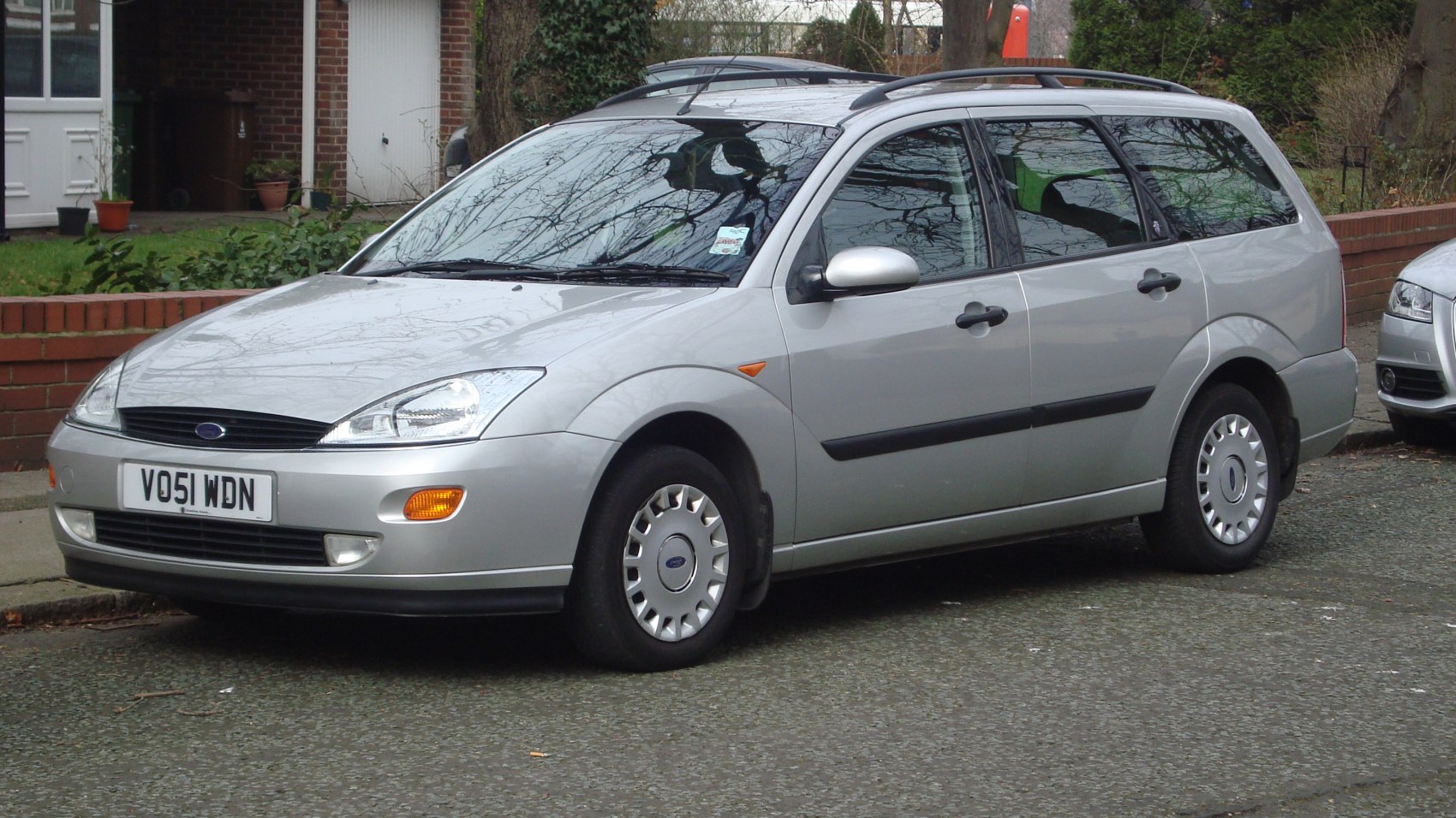 Silver estate vehicle with roof rails and hubcaps from front side view