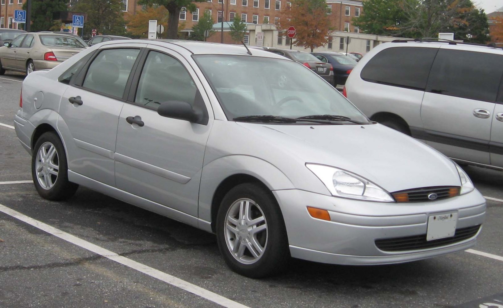 Silver four-door sedan showing front side view with headlights and alloy wheels