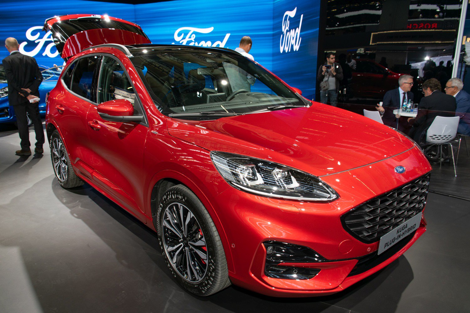 Red SUV front view with LED headlights, alloy wheels, and open trunk