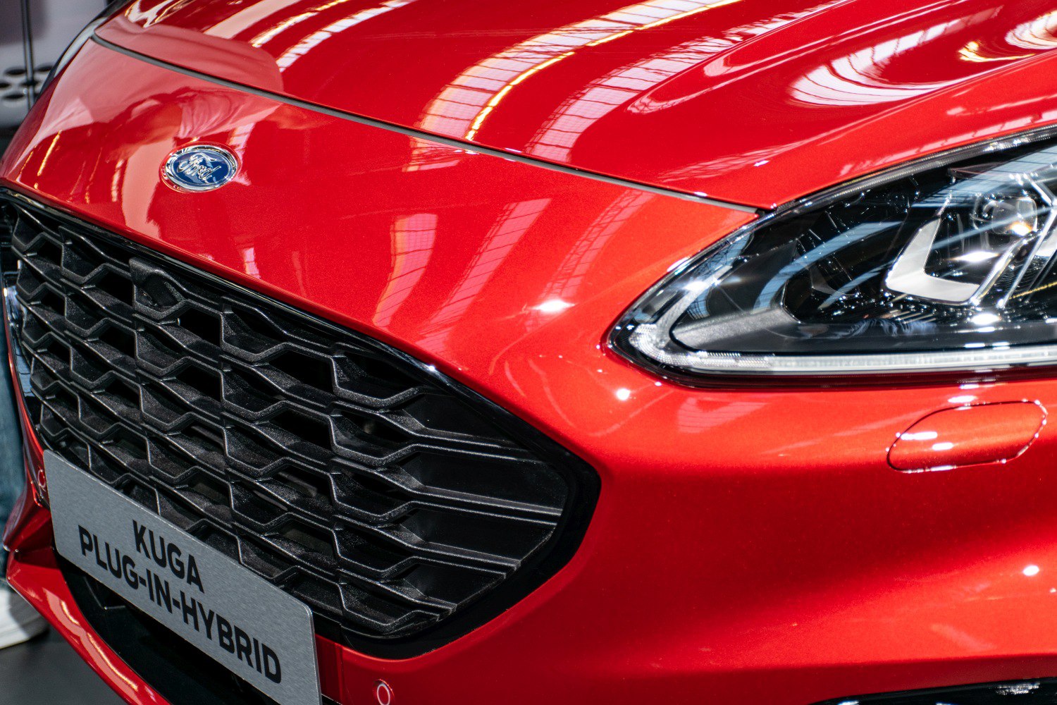 Close-up on front grille and headlight with Ford emblem.