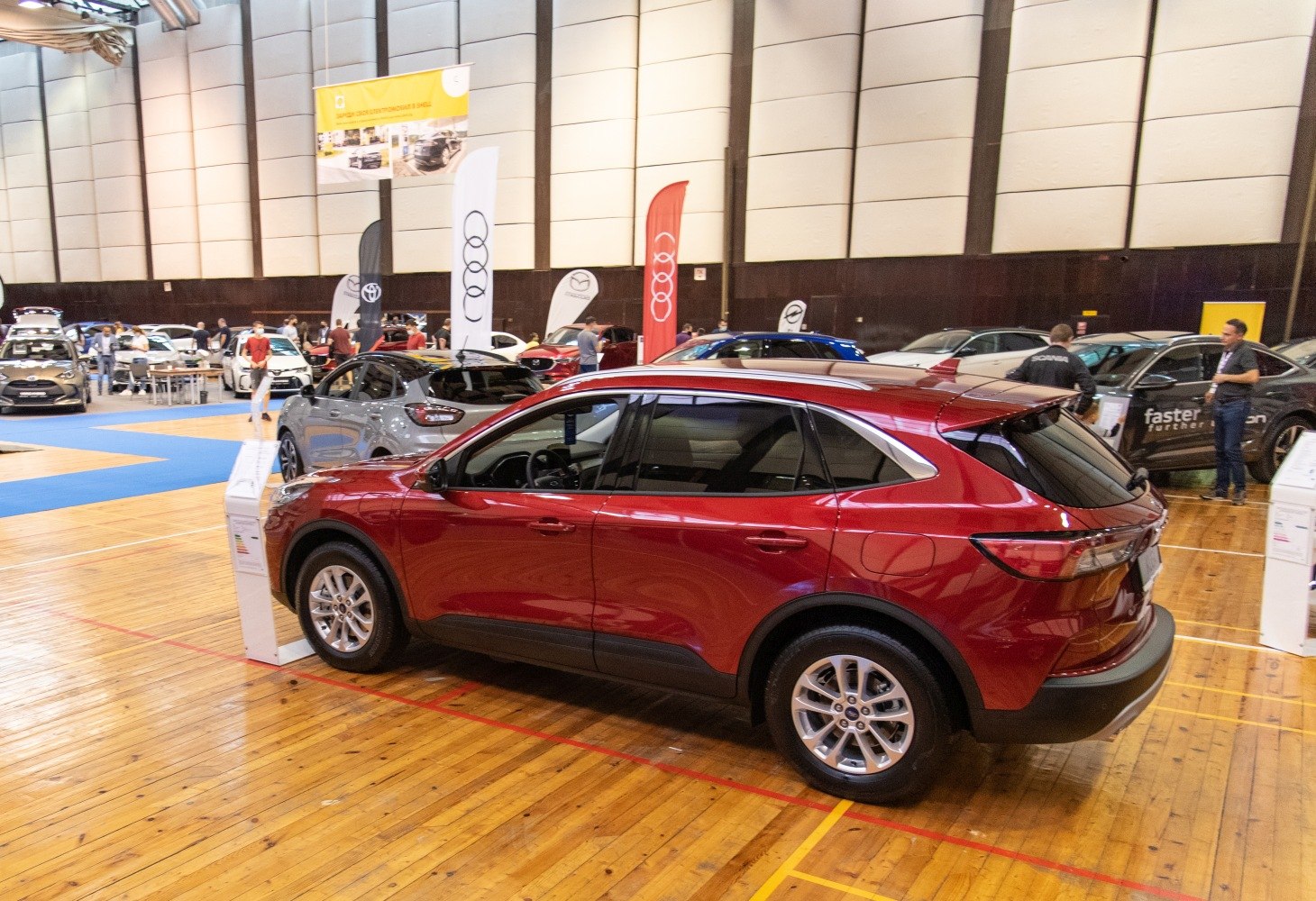 Red SUV with sharp rear lights and tinted windows in indoor exhibition
