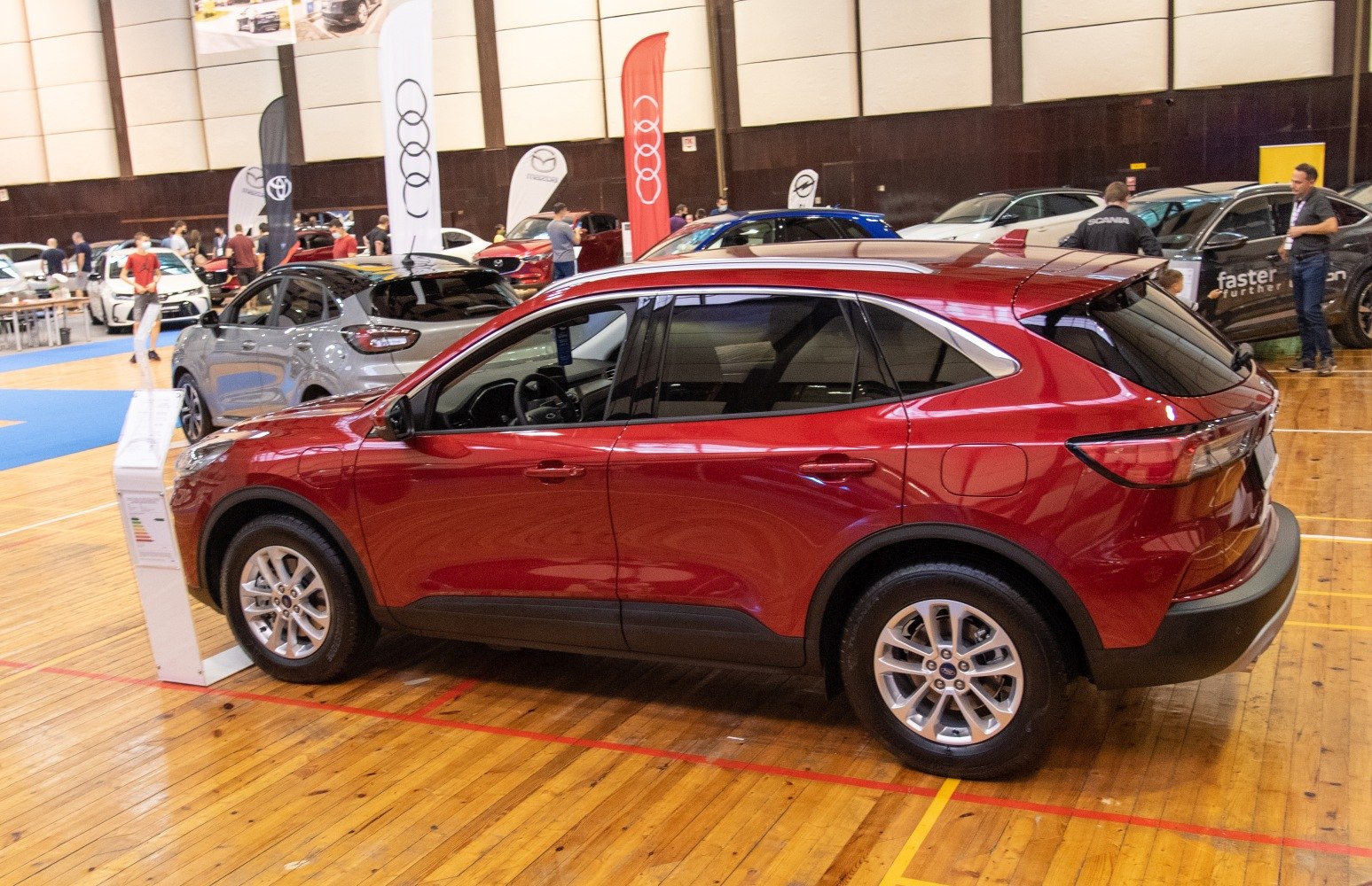 Side view of a red modern SUV with alloy wheels indoors