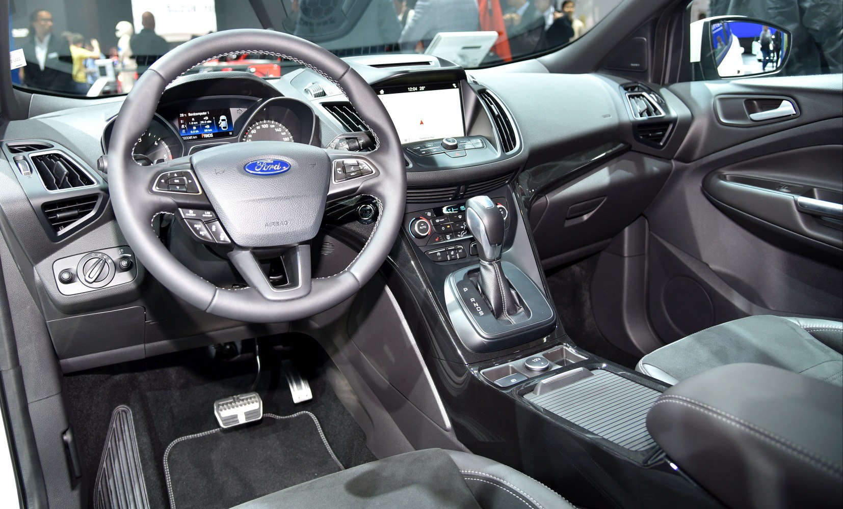 Steering wheel, digital instrument cluster, and gear shift inside a modern vehicle interior