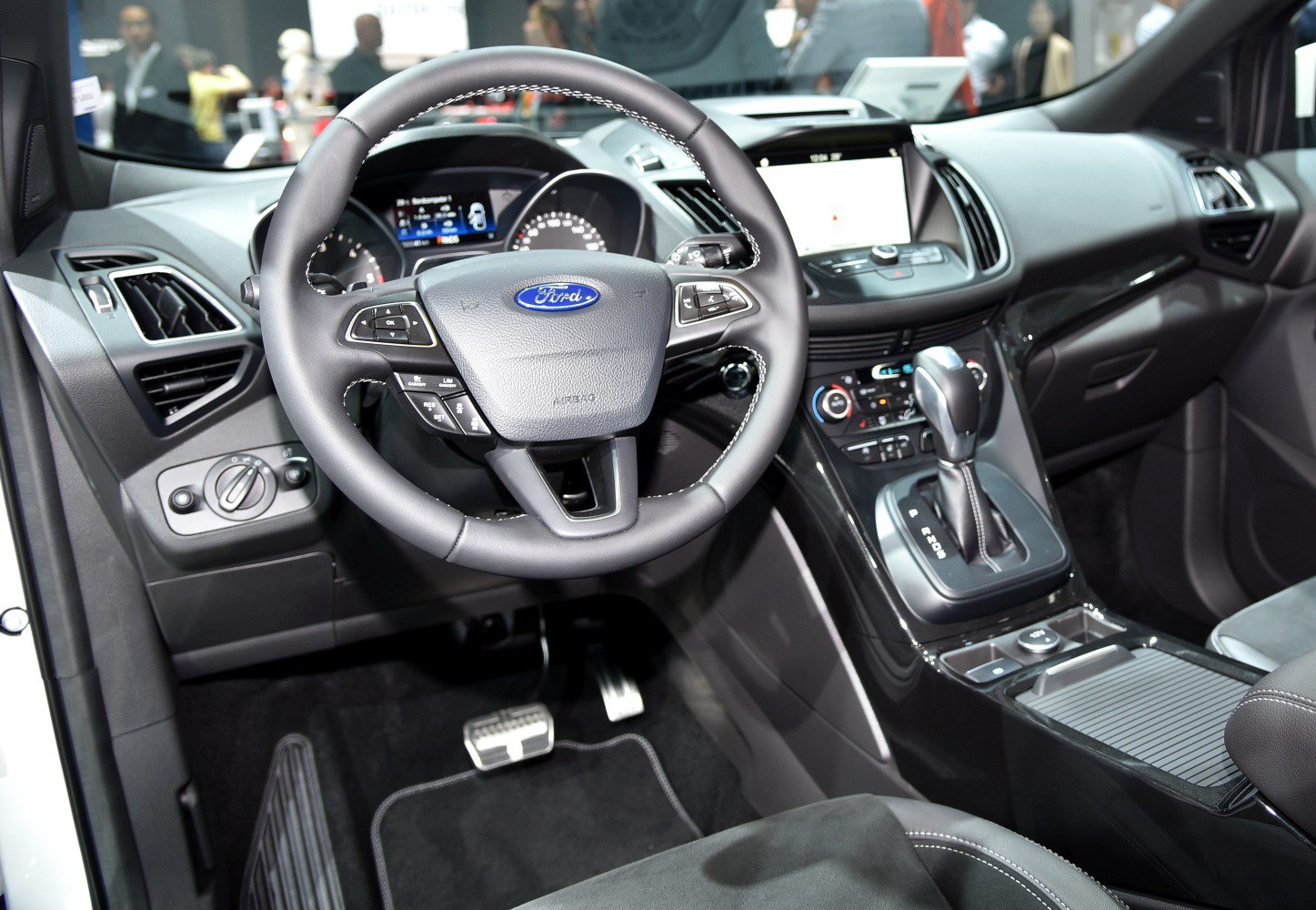 Steering wheel, dashboard, and center console of a vehicle interior.