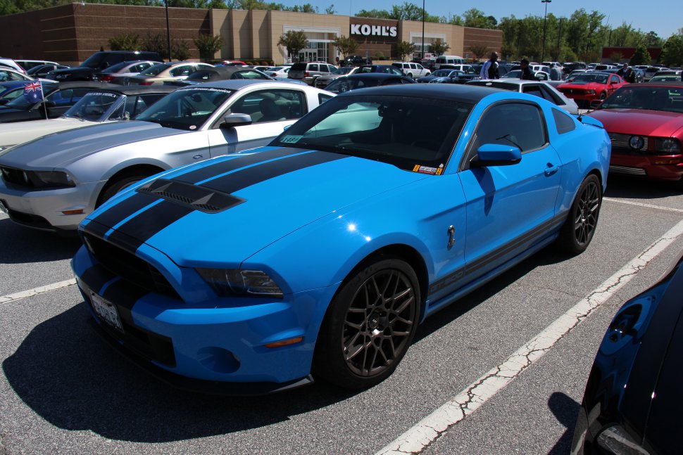 Blue sports coupe with black racing stripes, vented hood, and dark alloy wheels
