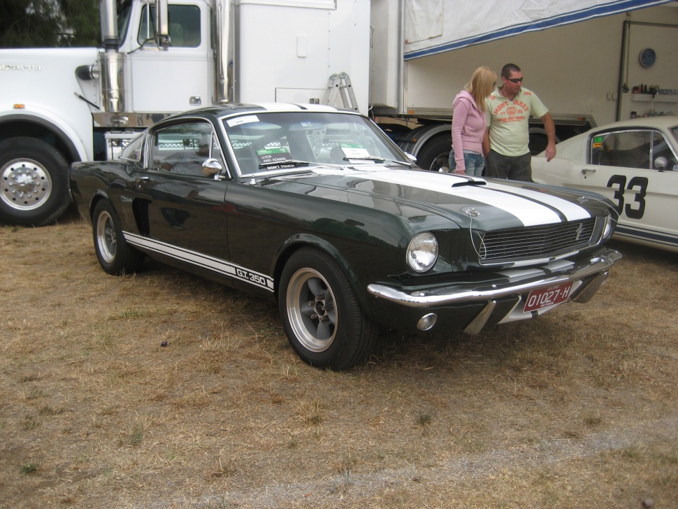 Classic 1960s muscle car with dual racing stripes and fastback design