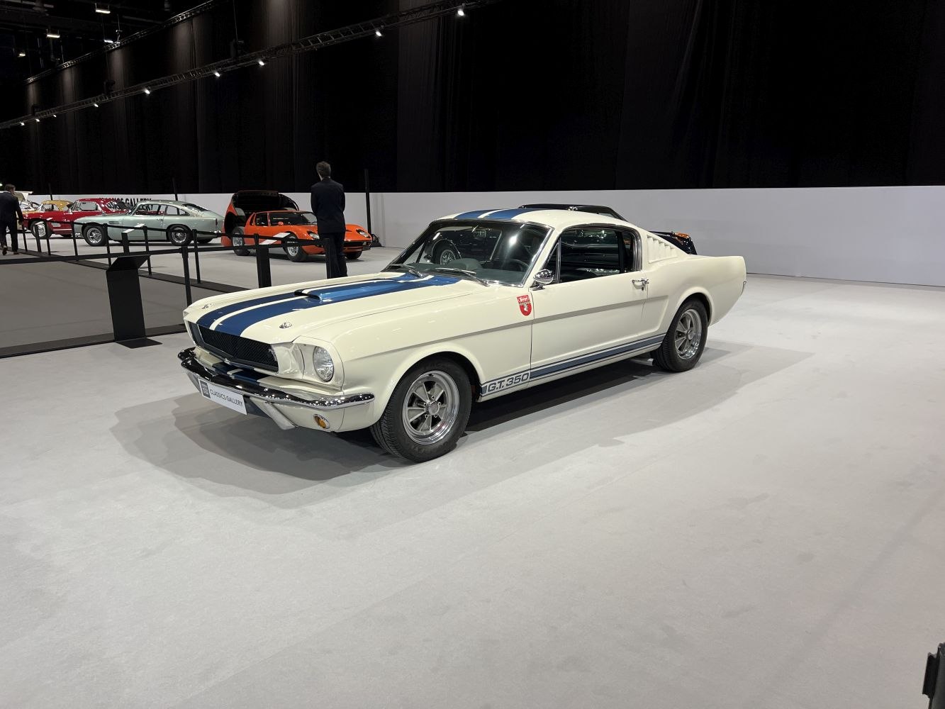 White Shelby GT350 with distinctive blue racing stripes and classic muscle car styling