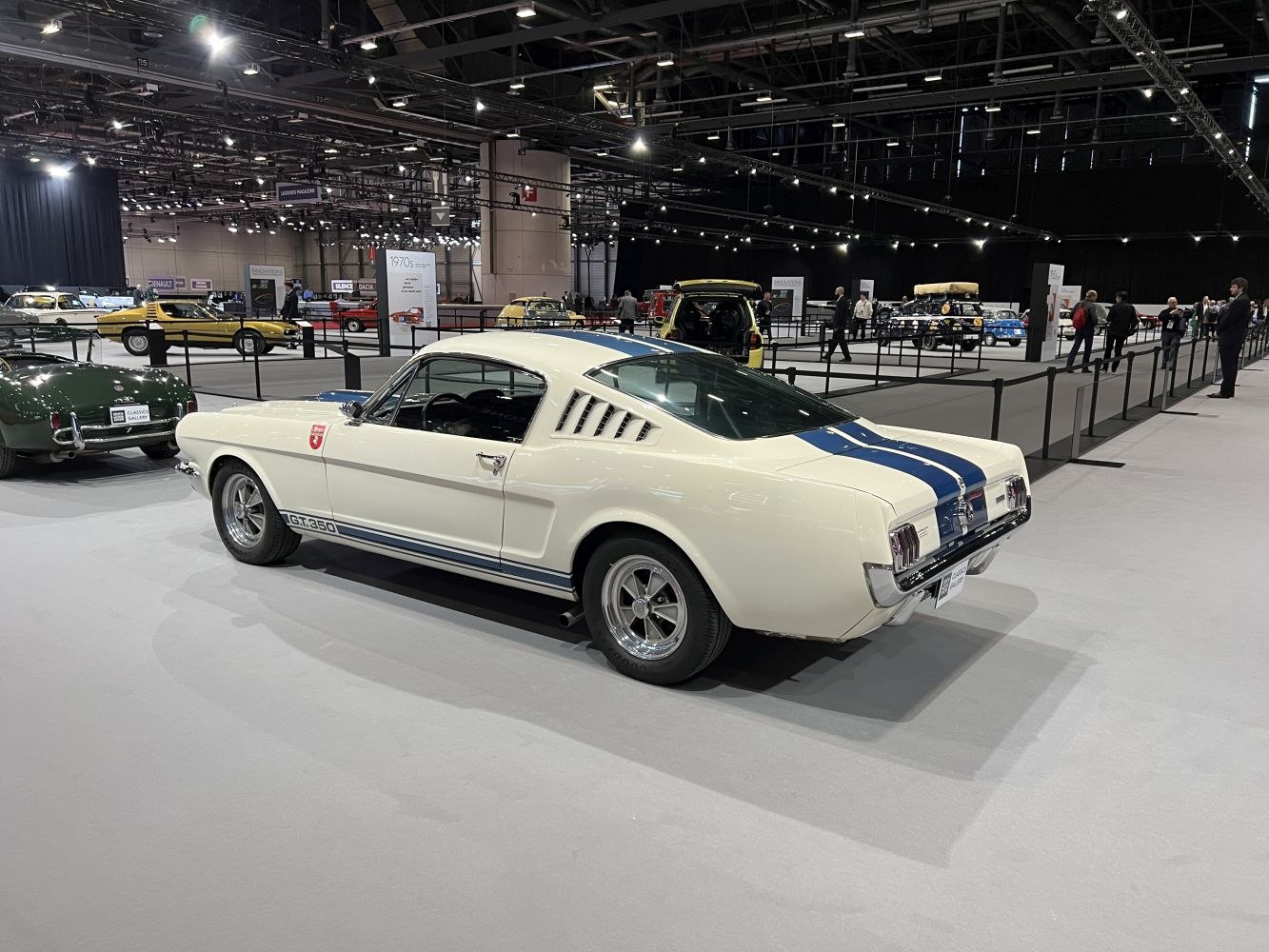 Vintage fastback muscle car with blue racing stripes and side air vents