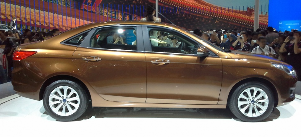 Metallic brown compact sedan side profile with alloy wheels