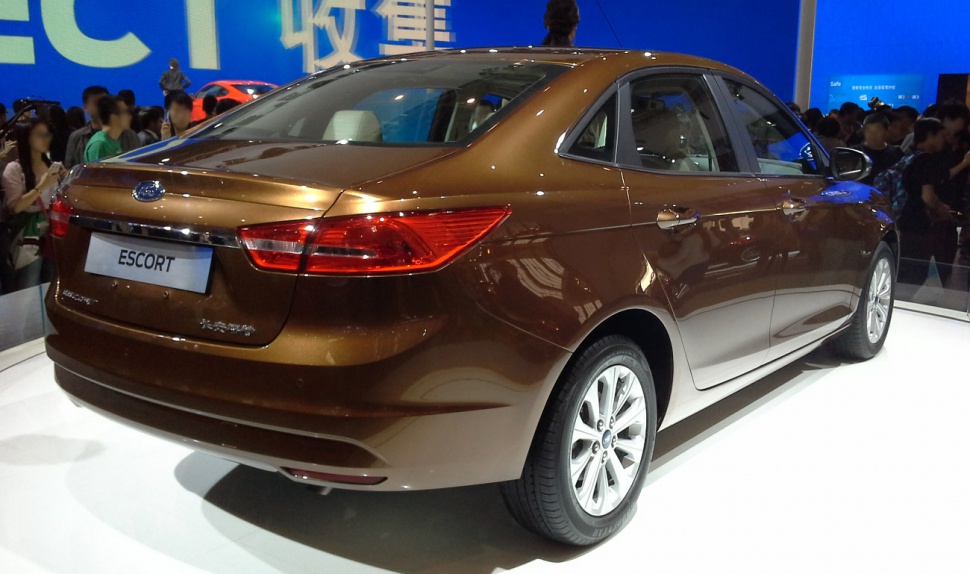 Rear and side view of a brown compact sedan with distinct tail lights.