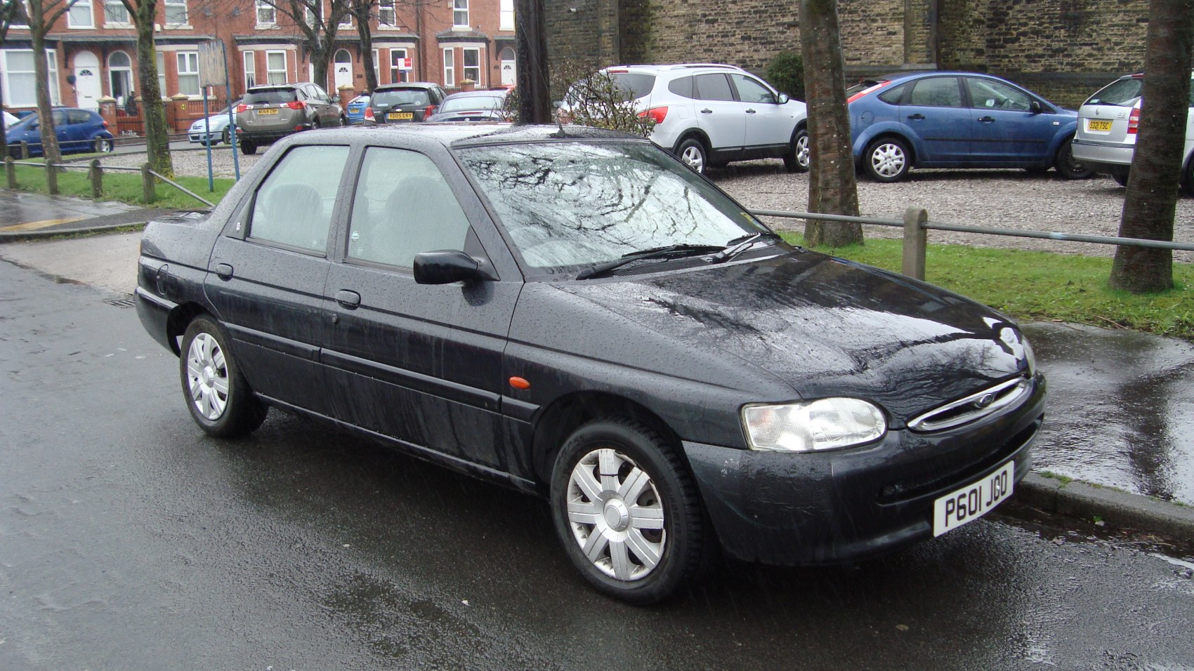 Black compact sedan with front headlights and alloy wheels