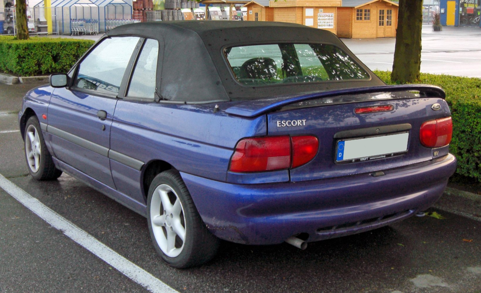 Convertible car with black soft top and rear spoiler