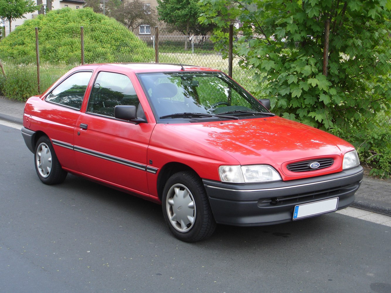 Red two-door compact hatchback with rounded headlights and black bumper trim