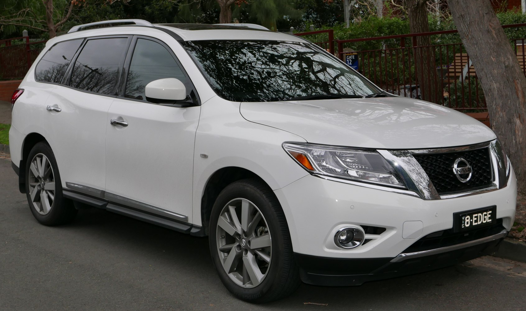 White SUV with chrome grille, alloy wheels, roof rails, and tinted windows