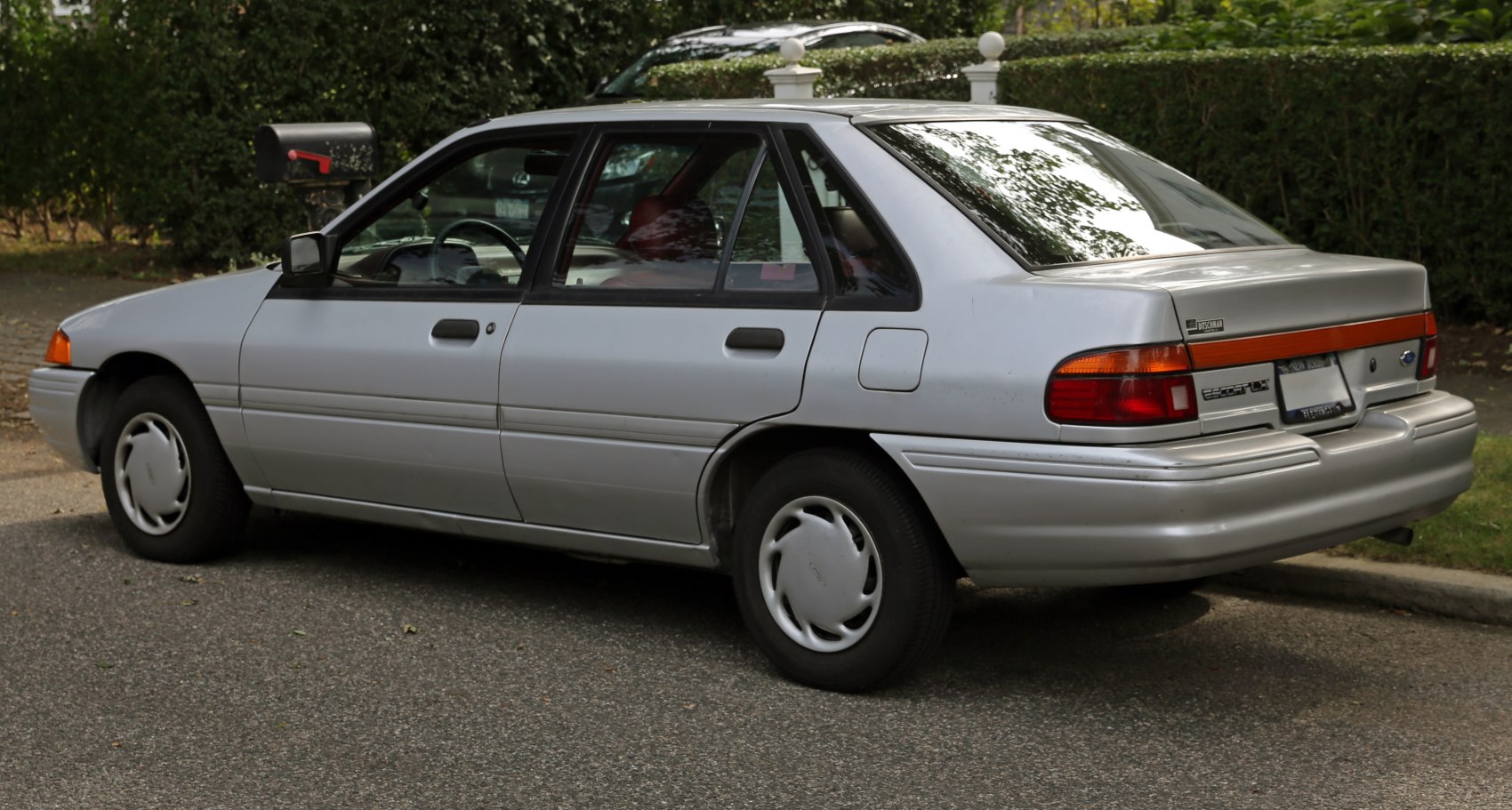 Side profile of a silver four-door sedan with classic rear design.