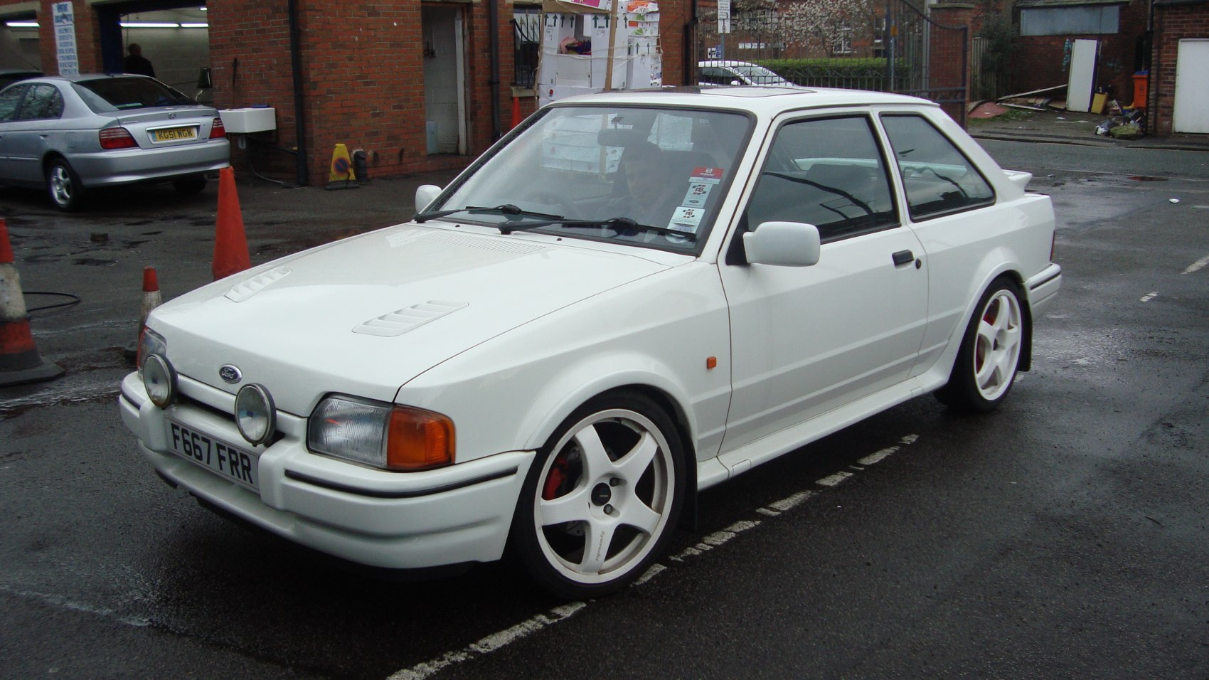 White hatchback with sporty five-spoke wheels and front mounted spotlights