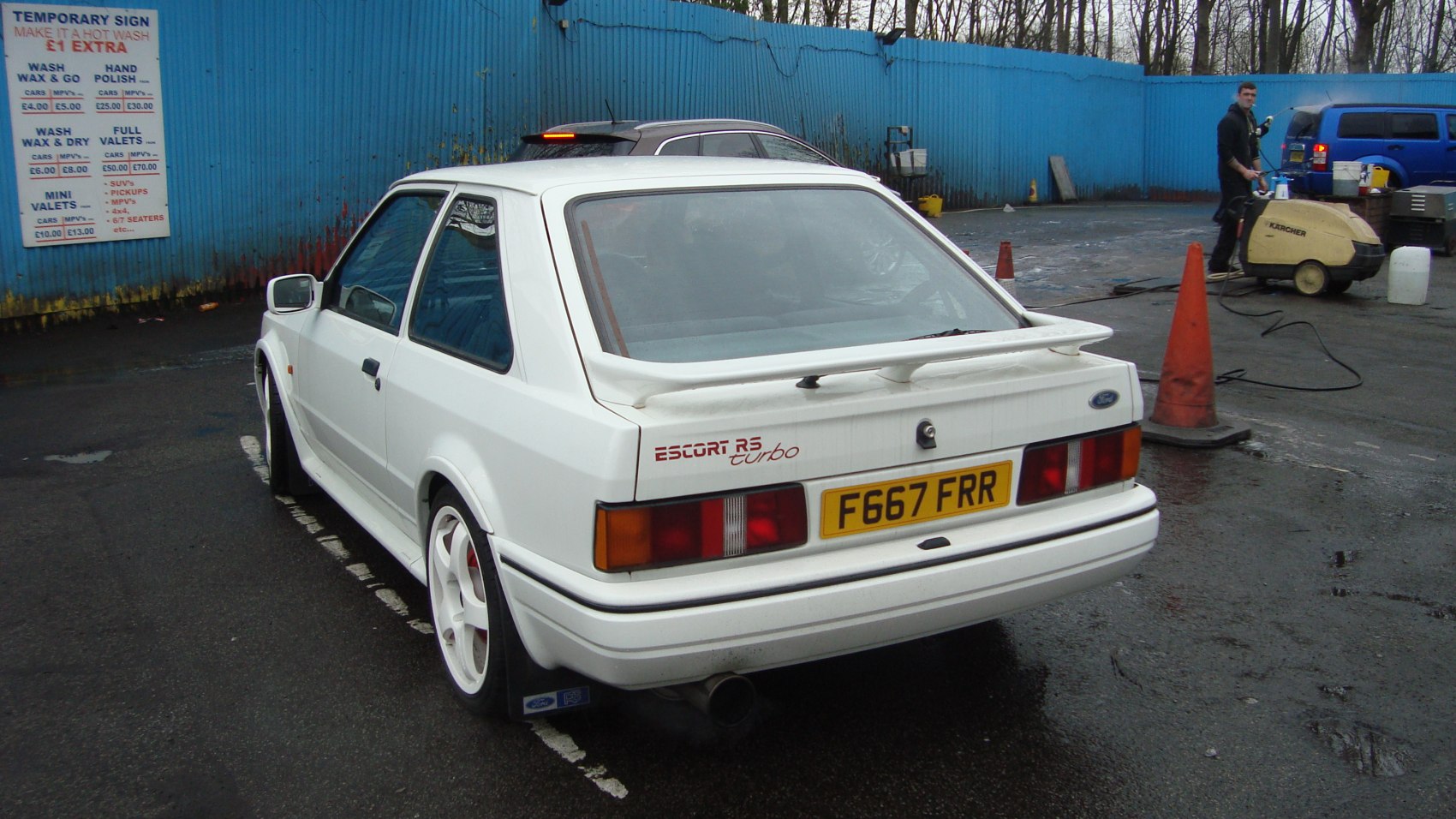 Rear view of white hatchback with spoiler and alloy wheels