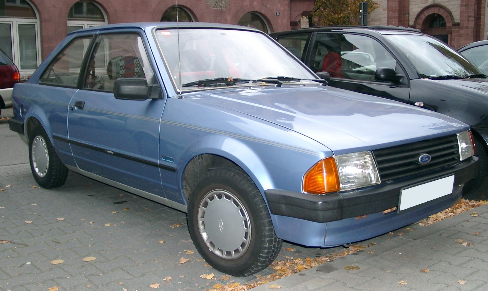 Angular hatchback front-side view with rectangular headlights and black grille