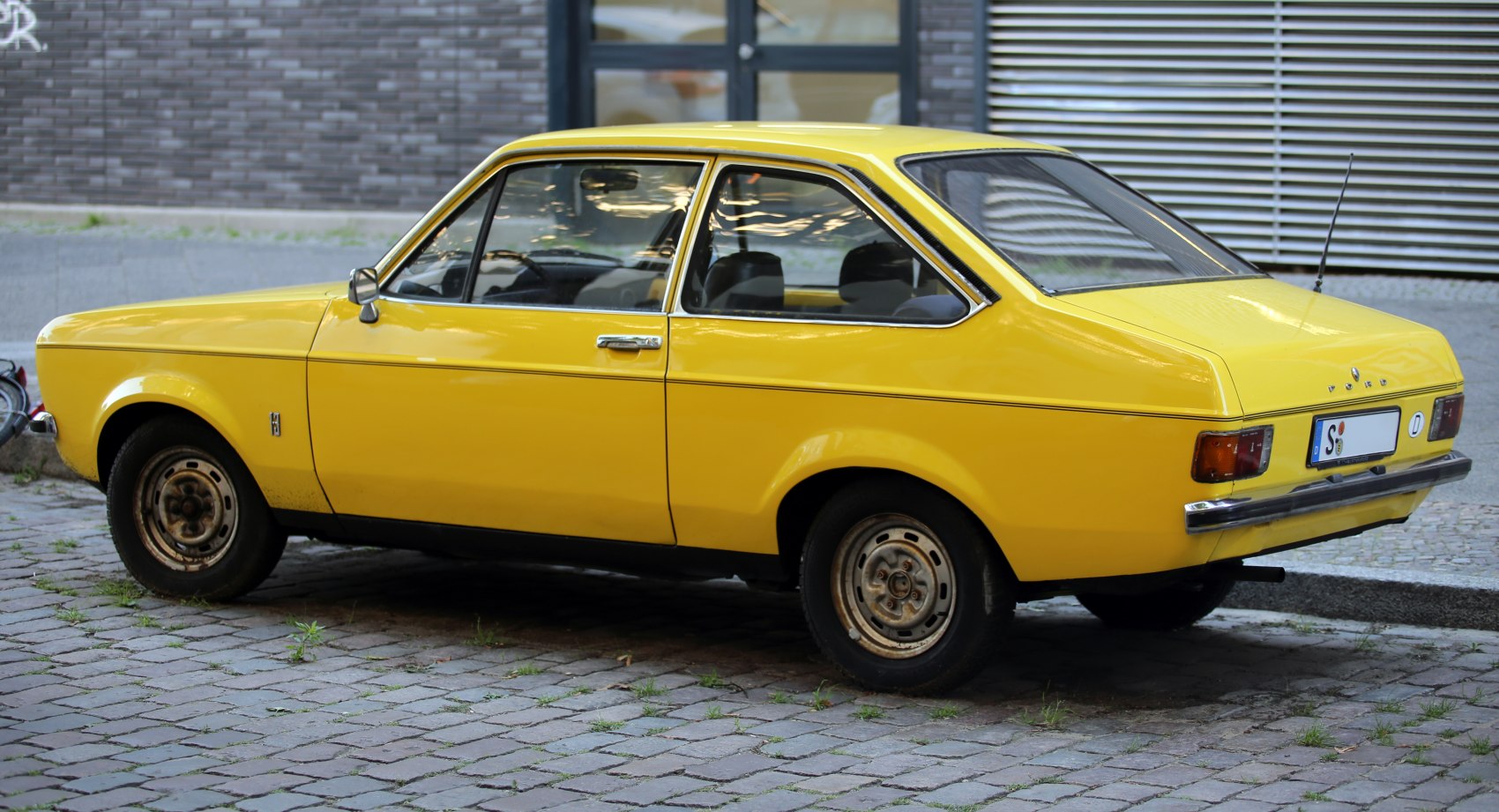 Yellow classic compact coupe showing side and rear views