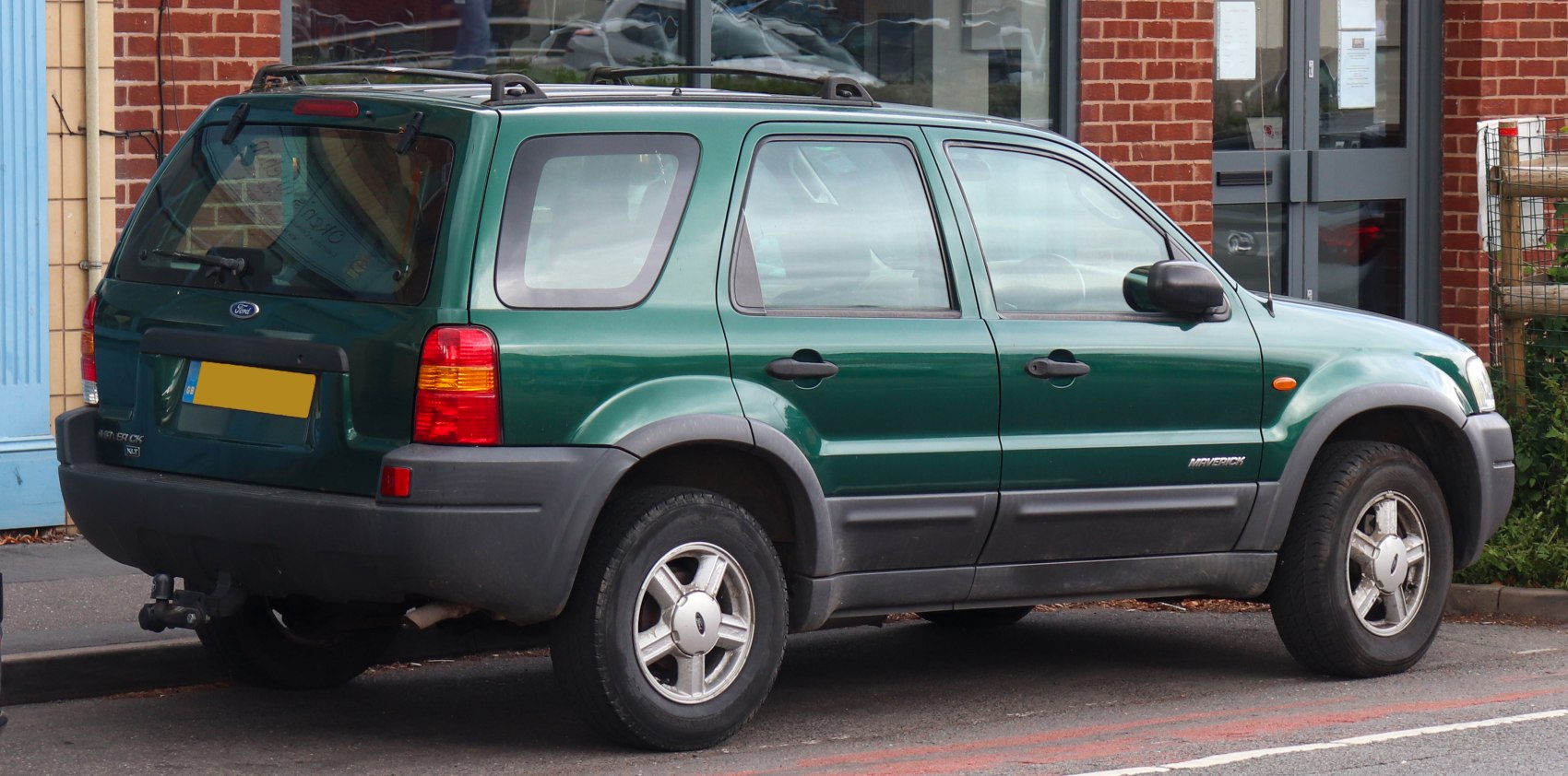 Green SUV with roof rails and alloy wheels in side-rear view