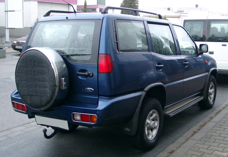 Rear side view with spare wheel cover and side steps on an SUV