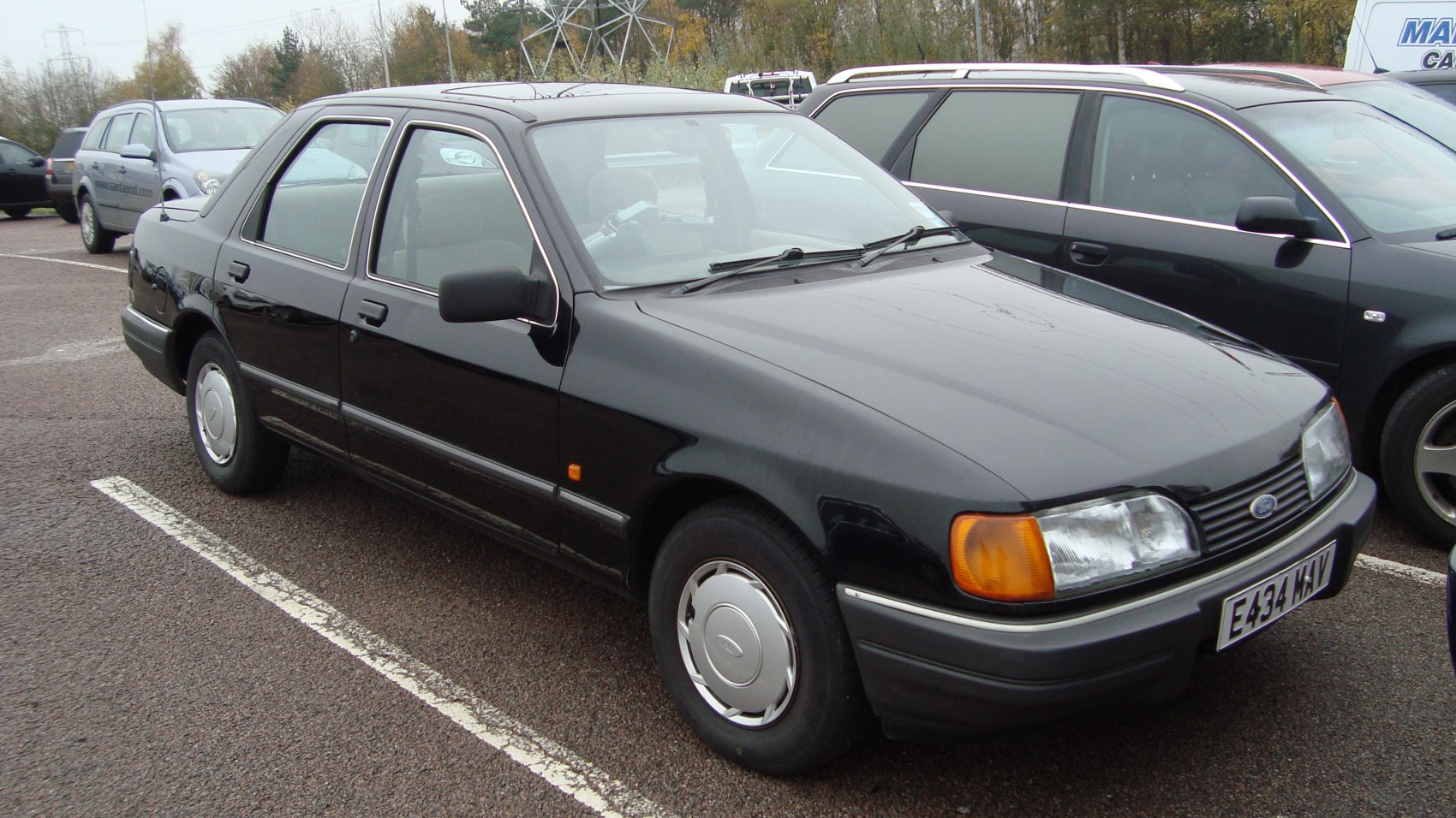Front-side view of classic sedan with hubcaps and squared headlights