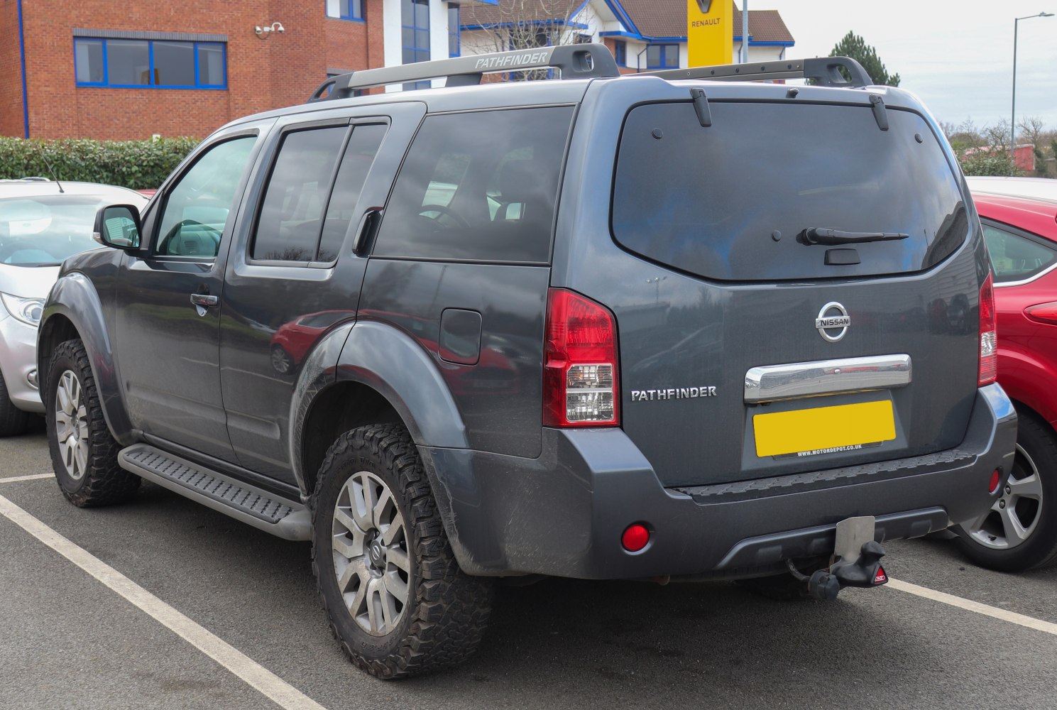 Rear and side view of large SUV with roof rails and rugged tires