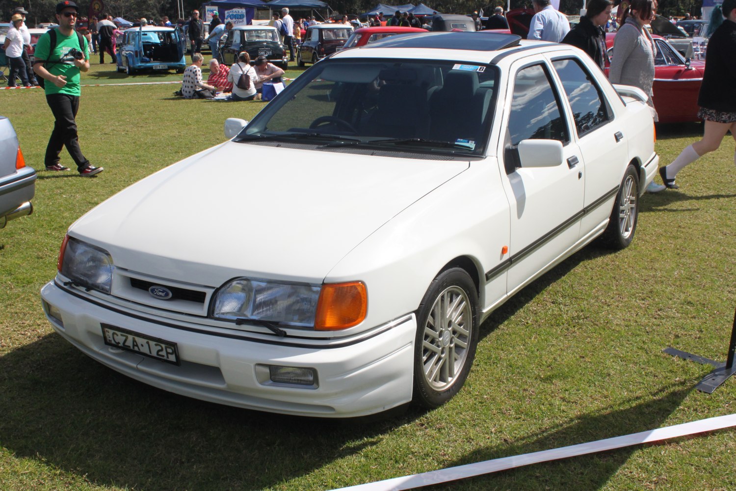 White classic sedan with sporty alloy wheels and distinctive front design