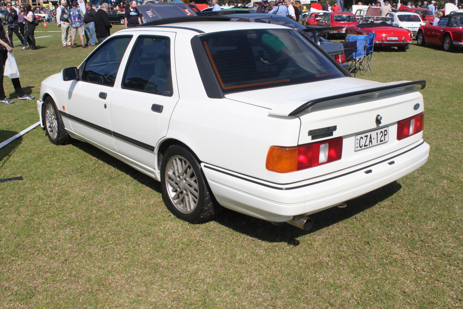 White sedan with rear spoiler and classic rear taillights.