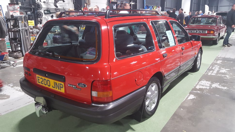 Red estate wagon rear-side view with roof rails and trailer hitch