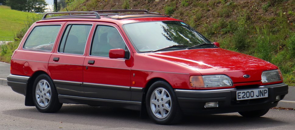 Red station wagon with roof rails and classic design.