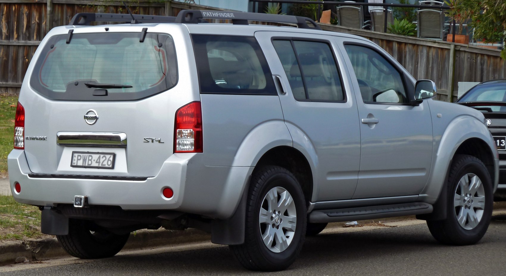 Rear side view of a mid-2000s SUV with rugged body and roof rails