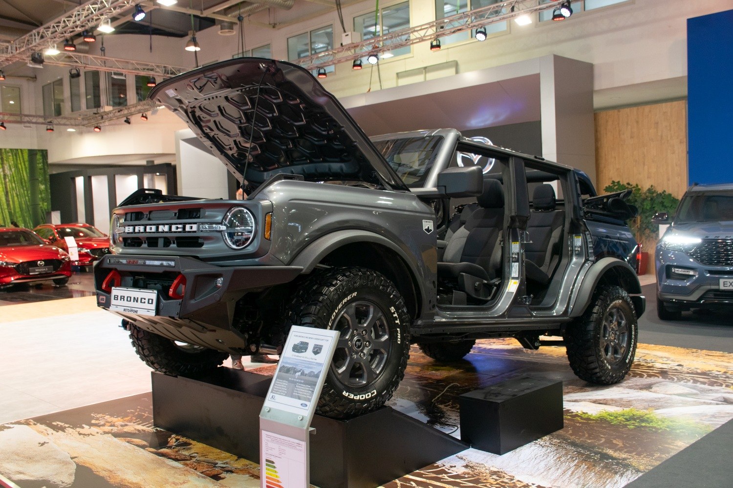 Four-door SUV with open doors and hood, off-road tires, and lifted suspension
