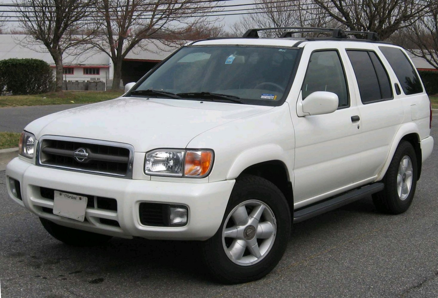 White SUV with alloy wheels and roof rack, side-front view