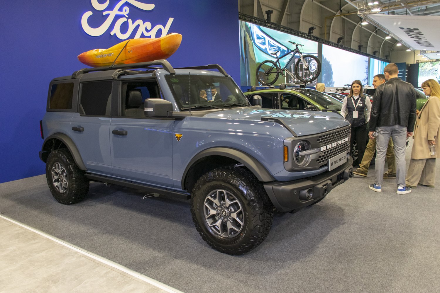 Four-door SUV with off-road tires and roof-mounted kayak
