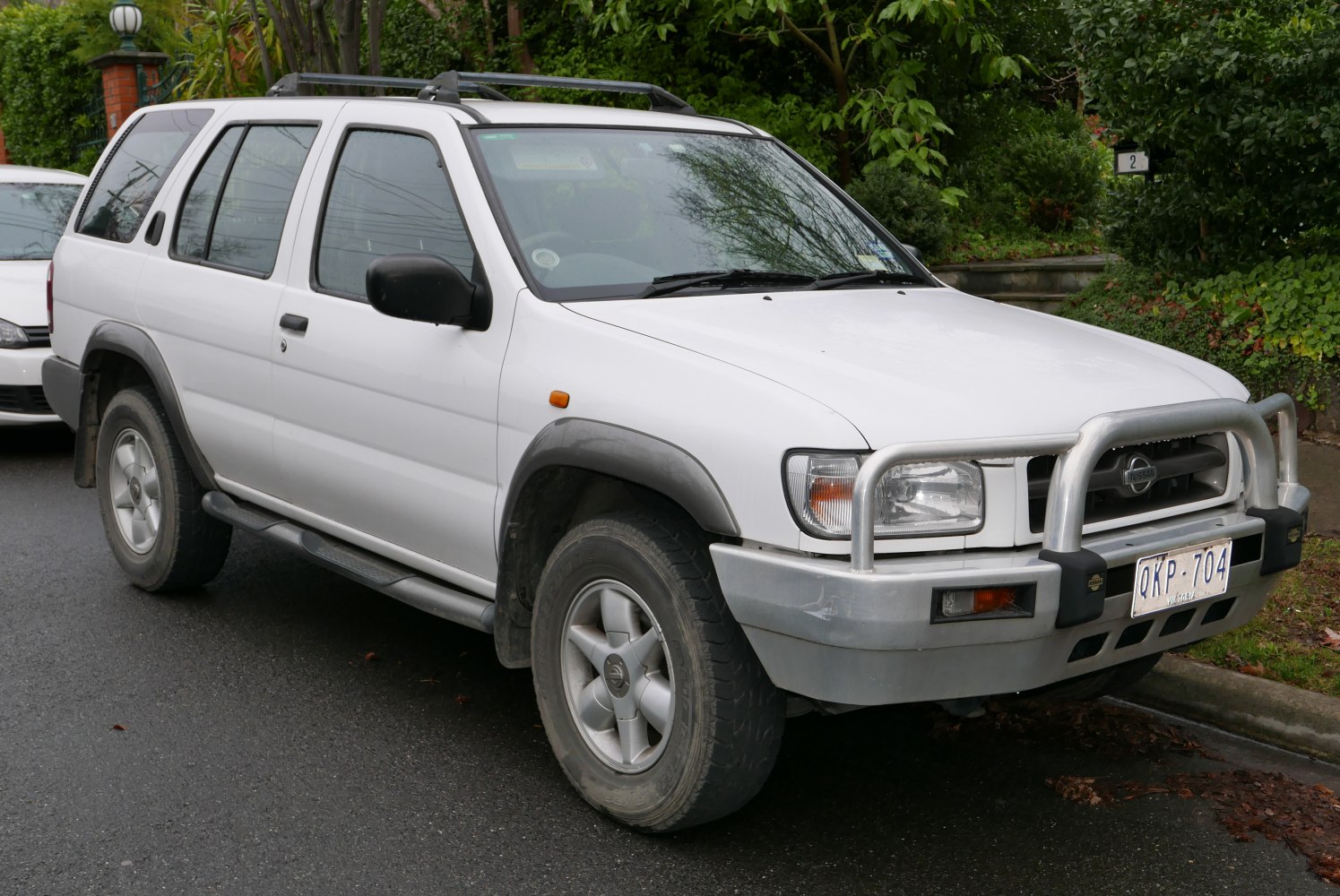 White SUV with metal bull bar and roof rack
