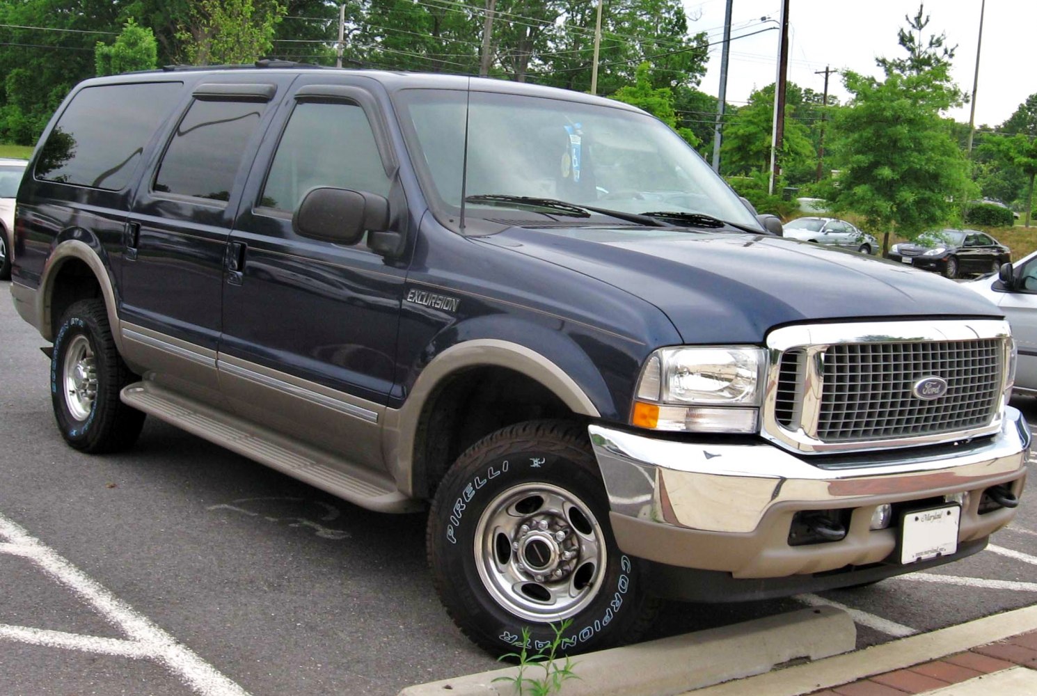 Front and side view of large SUV with chrome grill and two-tone paint