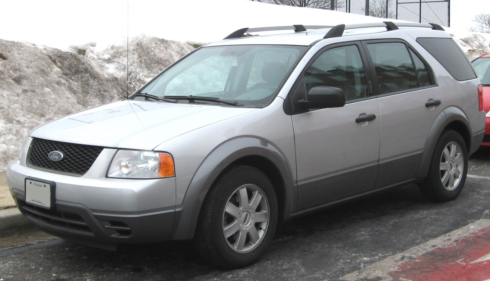 Silver mid-size SUV front side view with roof rails